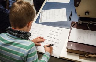 Kind entschlüsselt alte Schriften im Archiv