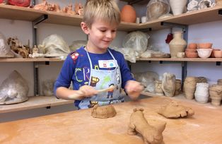 Kind beim Arbeiten mit Ton in der Keramikwerkstatt