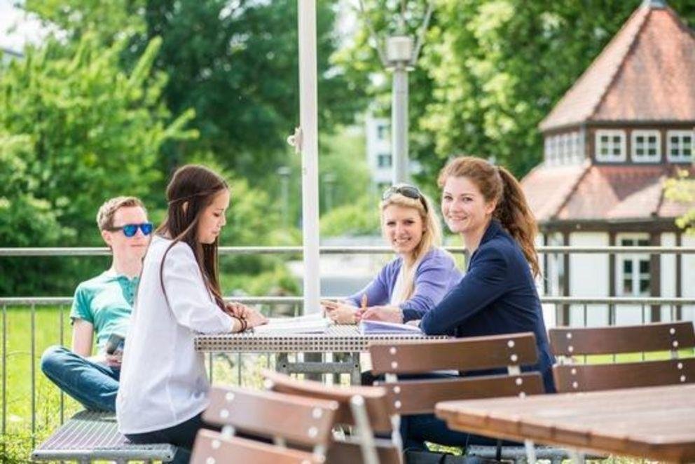 Studierende sitzen an einem Tisch in der Natur