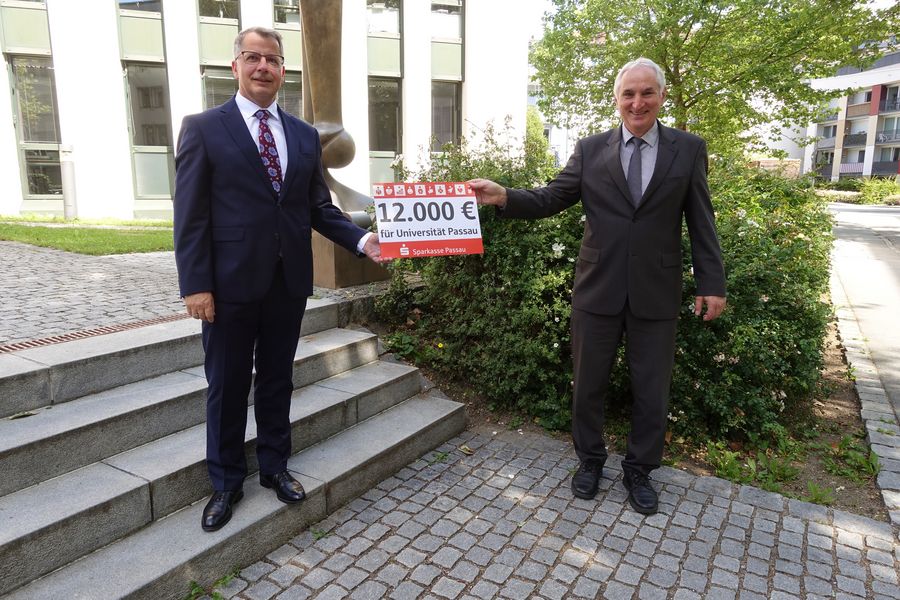 Das Bild zeigt Christoph Helmschrott und Präsident Prof. Dr. Ulrich Bartosch bei der Spendenübergabe. Foto: Universität Passau