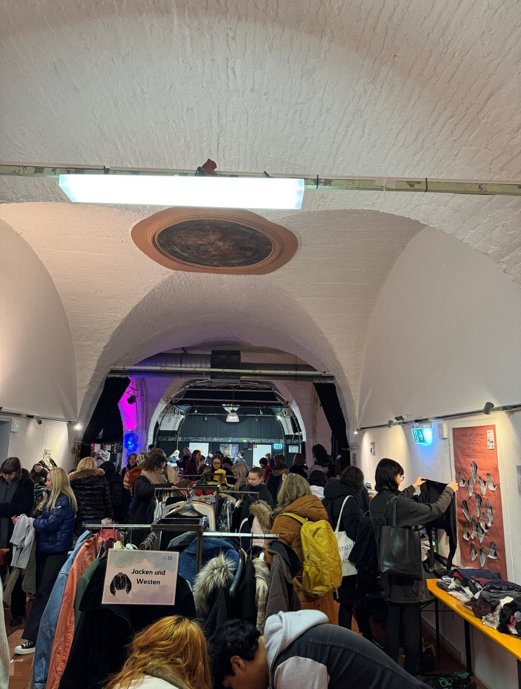 Raum voller Menschen mit vielen Kleiderst&auml;ndern 