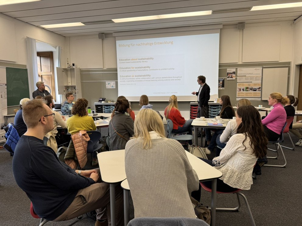 Prof. Dr. Andreas Eberth (stehend rechts) erläutert den Teilnehmenden wichtige Punkte einer Bildung für nachhaltige Entwicklung. Stehend links im Bild: Dr. Hannes Birnkammerer; Foto: Universität Passau