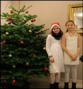 Zwei Schülerinnen neben dem Weihnachtsbaum