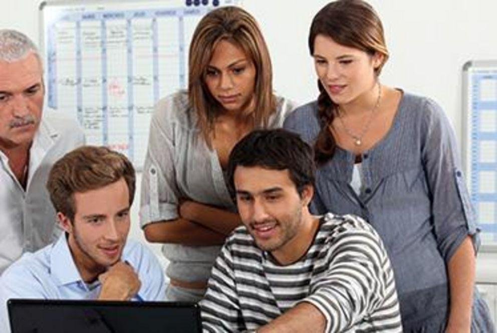 Five international students look at a notebook computer