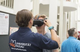Dieser Besucher befindet sich gerade in einer virtuellen Welt. Tobias Baumgärtner, wissenschaftlicher Mitarbeiter im Projekt ViSIT, hat ihn dorthin mit Hilfe dieser Virtual Reality Brille gebracht.