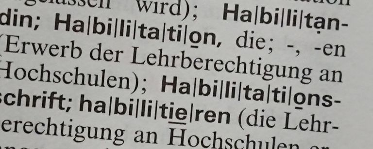 The picture shows an excerpt from the German dictionary Duden, including the word 'Habilitation'.