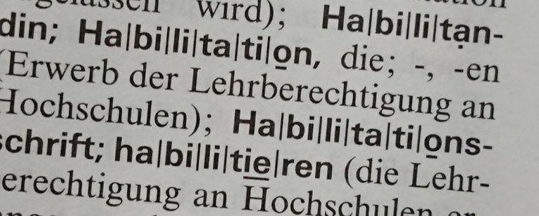 Das Bild zeigt einen Ausschnitt aus dem Duden und unter anderem das Wort "Habilitation".