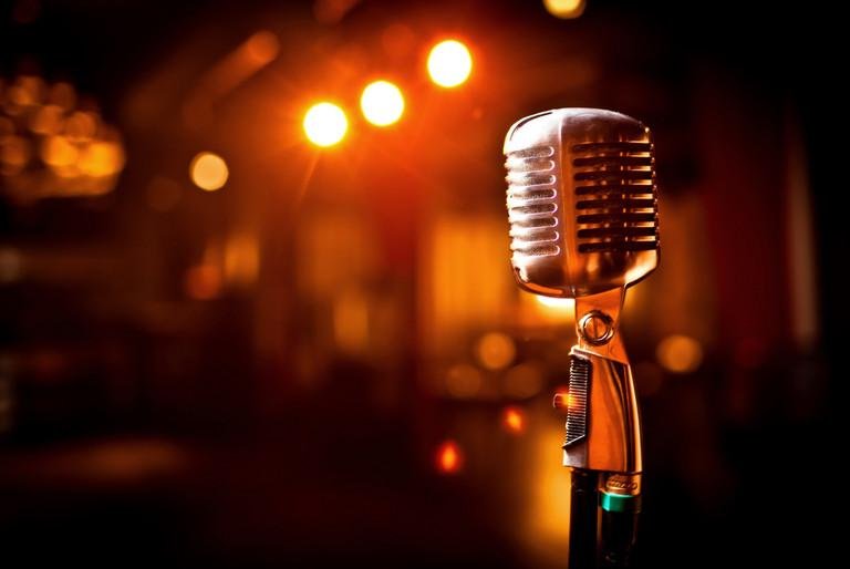 Picture of a microphone and a stage in the background