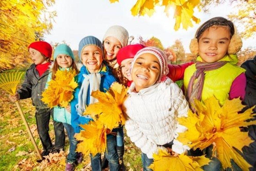 Kinder spielen im Herbstlaub