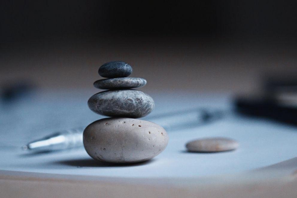 Stones balanced on top of each other next to writing utensils