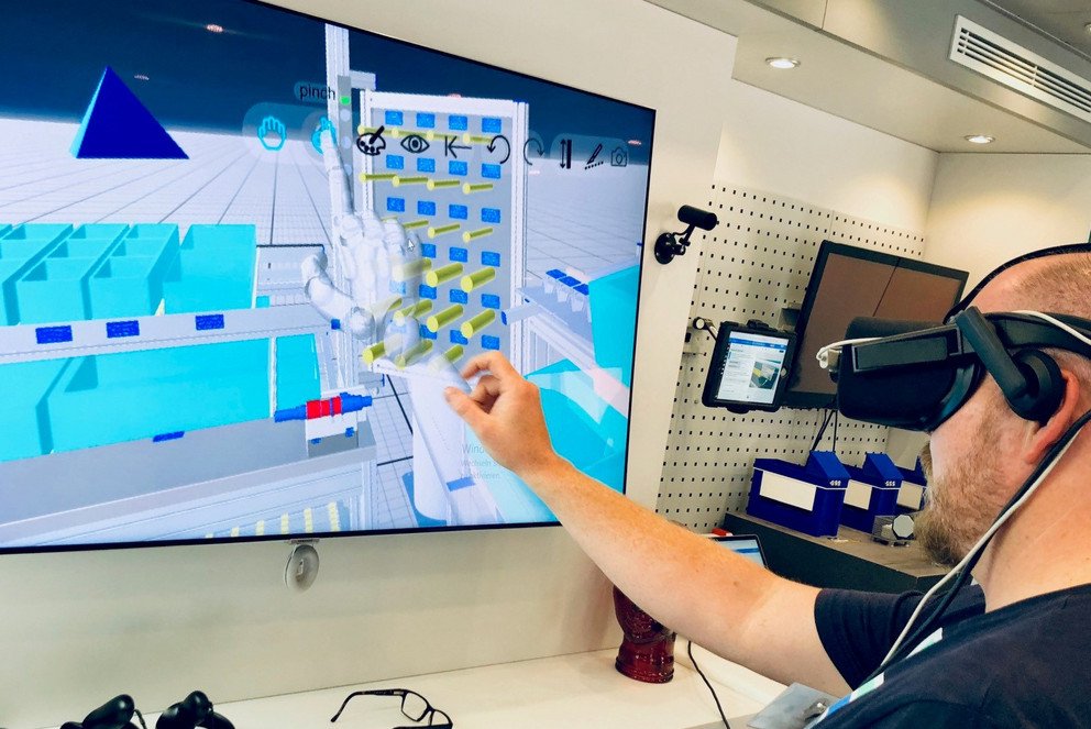 Ein Mann beschäftigt sich an einem Bildschirm mit einer Virtual Reality Applikation.