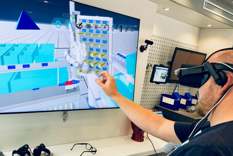 Ein Mann beschäftigt sich an einem Bildschirm mit einer Virtual Reality Applikation.