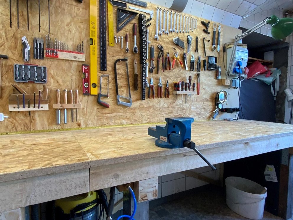 Aufger&auml;umte Werkbank. Werkzeug h&auml;ngt an der Wand