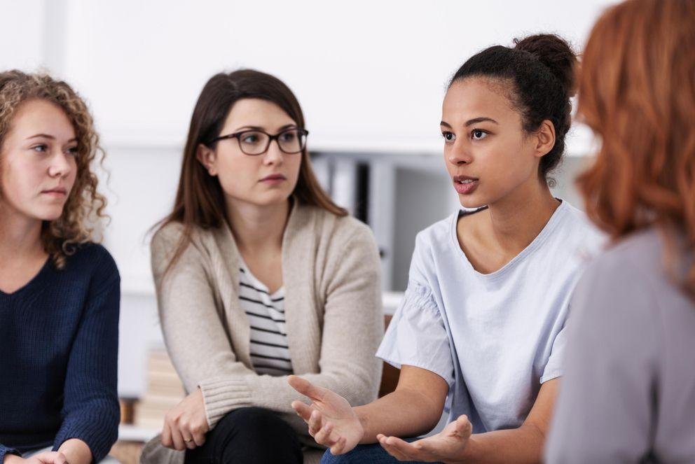 eine Gruppe diverser Frauen, die in eine Diskussion vertieft sind