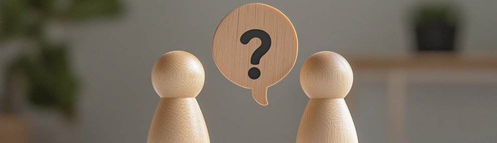 Picture of two wooden figures, one of whom is asking a question