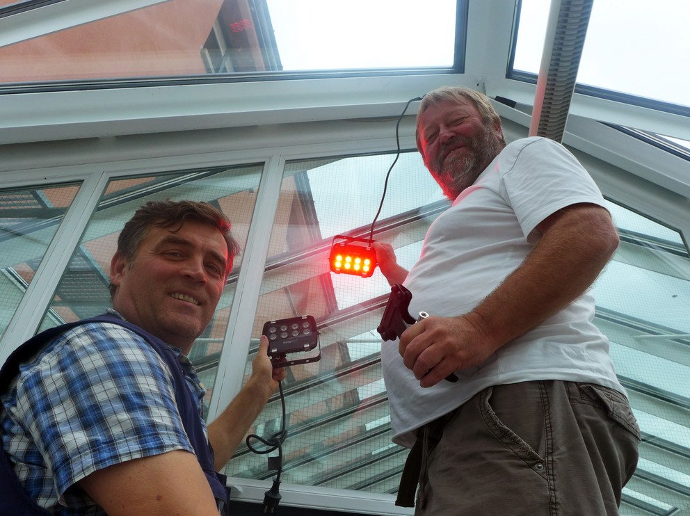 Bildhinweis: Die Elektrik ist schon startbereit: K&uuml;nstler Hubert Huber und Uni-Betriebstechniker Ante Sučić testen die farbige Beleuchtung f&uuml;r die Lichtinstallation im Rahmen der EW. Foto: Universit&auml;t Passau