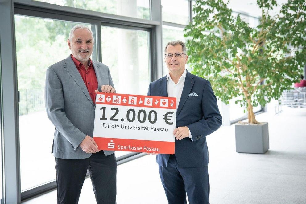 Präsident Prof. Dr. Ulrich Bartosch (l.) freut sich über den Scheck in Höhe von 12.000 Euro der Sparkasse Passau, übergeben von Christoph Helmschrott, Vorstandsvorsitzender der Sparkasse Passau, Foto: Universität Passau