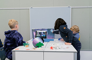 Kinder drehen einen Stop-Motion-Film mit Hilfe eines Tablets.