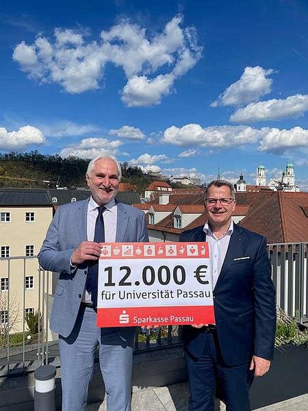 Prof. Dr. Ulrich Bartosch, Präsident der Universität Passau (l.), gemeinsam mit Christoph Helmschrott, Vorstandsvorsitzender der Sparkasse Passau, bei der Spendenübergabe, Foto: Universität Passau 