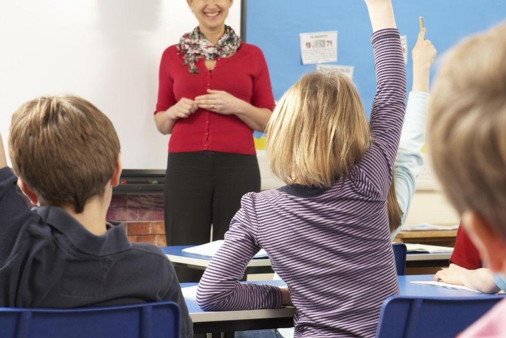 Lehrerin und Schülerinnen und Schüler im Klassenzimmer