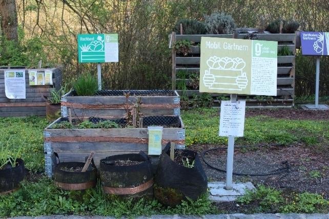 Hochbeete mit Schildern "Mobil Gärtnern" und "Vertikales Gärtnern", frisch bepflanzt