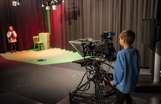 Kind hinter der Kamera im TV-Studio