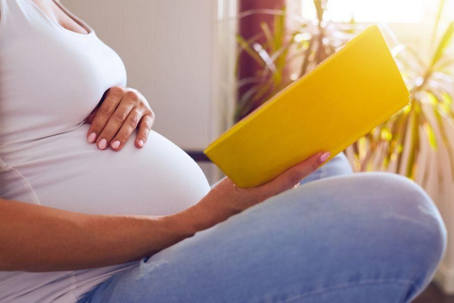 Schwangere Frau mit Buch