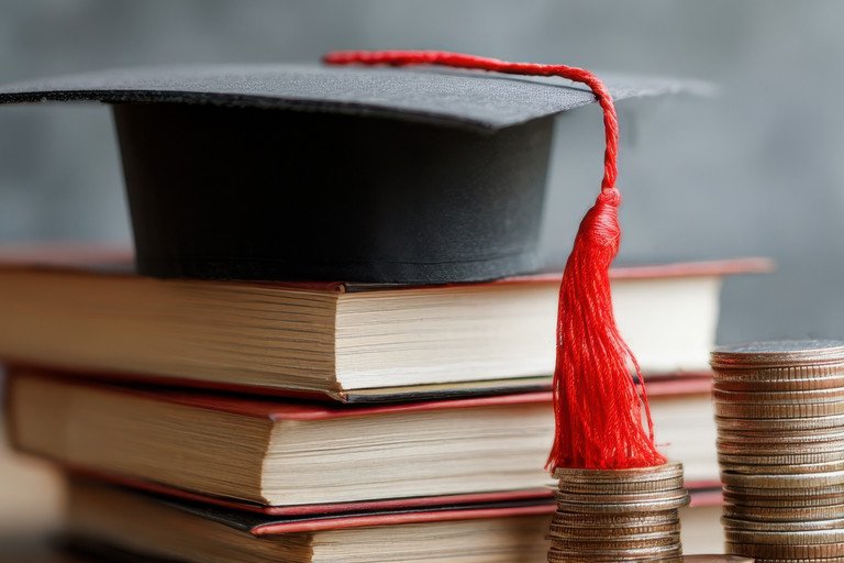 graduation cap with books and coins