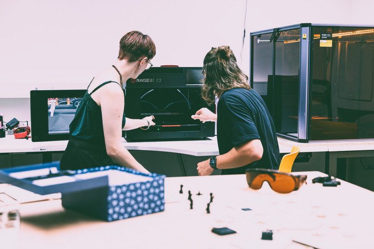 Bild zeigt zwei Studenten an einem 3D-Drucker