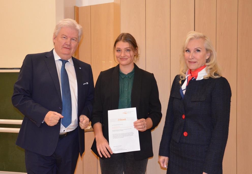 Prof. Sigmund Gottlieb (li), ehemaliger Chefredakteur des Bayerischen Fernsehens, und Prof. Dr. Christina Hansen (re), Vizepräsidentin für Internationales und Diversity, überreichten die Urkunde an Kateryna Myslytska; Foto: Nicola Jacobi