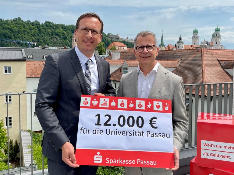 Prof. Dr. Jan Hendrik Schumann, Pr&auml;sident der Universit&auml;t Passau (l.), gemeinsam mit Christoph Helmschrott, Vorstandsvorsitzender der Sparkasse Passau, bei der Spenden&uuml;bergabe; Foto: Universit&auml;t Passau