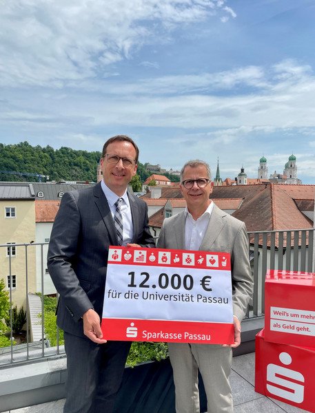Prof. Dr. Jan Hendrik Schumann, Pr&auml;sident der Universit&auml;t Passau (l.), gemeinsam mit Christoph Helmschrott, Vorstandsvorsitzender der Sparkasse Passau, bei der Spenden&uuml;bergabe; Foto: Universit&auml;t Passau