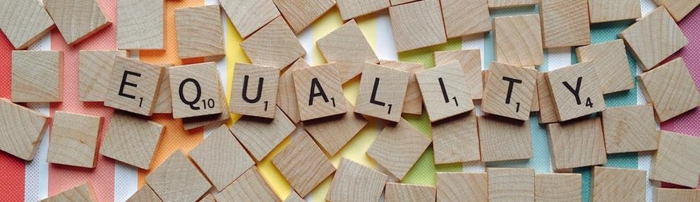 Holzklötze mit dem Wort Equality vor buntem Hintergrund