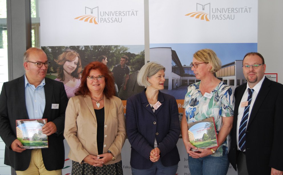 Prof. Dr. Klaus Beckmann aus Hamburg (l.) und Claudia Hopfe aus Langenhagen bei Hannover (2. v. r.) nahmen die l&auml;ngsten Anreisewege an ihre Alma Mater auf sich. Universit&auml;tspr&auml;sidentin Prof. Dr. Carola Jungwirth (M.), 3. B&uuml;rgermeisterin Erika Tr&auml;ger und Universit&auml;tsarchivar Mario Puhane w&uuml;rdigten dies mit einem Pr&auml;sent. Foto: Universit&auml;t Passau