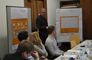 Zu sehen ist Dr. Christian Rademacher, wie er die Postersession zum Workshop präsentiert.
