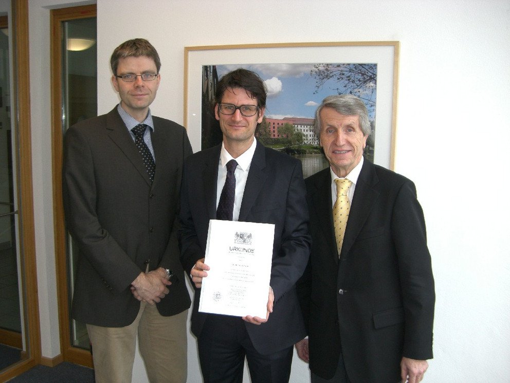 Professor Dr. Tomas Kuhn (Mitte) mit dem Dekan der Juristischen Fakult&auml;t Professor Dr. Wofgang Hau (rechts) und Universit&auml;tspr&auml;sident Professor Dr. Walter Schweitzer