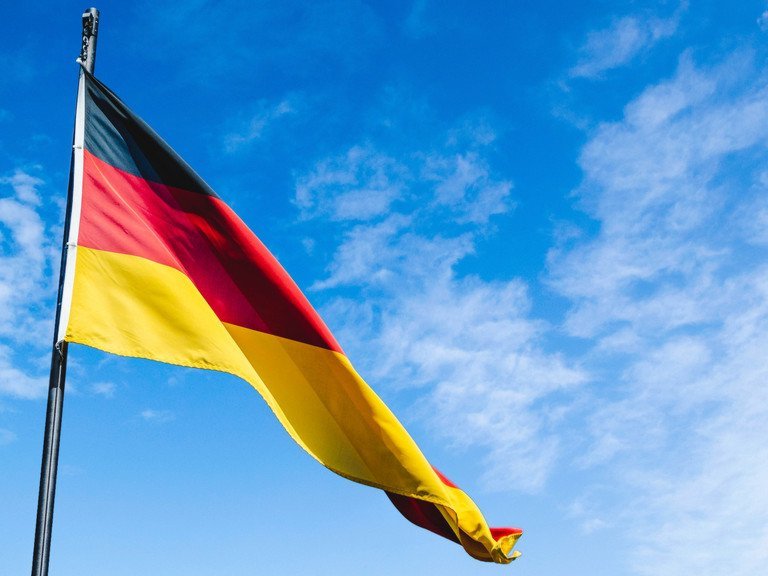Deutschlandflagge in schwarz-rot-gold vor blauem Himmel