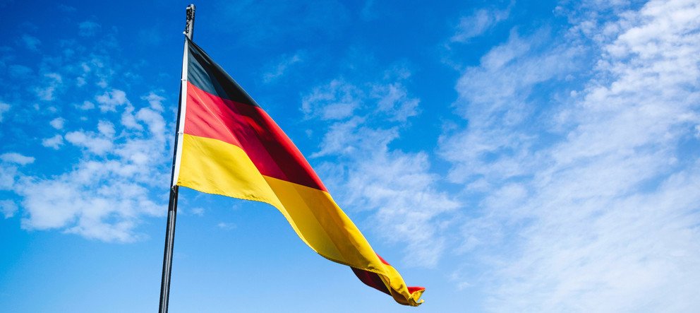 Deutschlandflagge in schwarz-rot-gold vor blauem Himmel