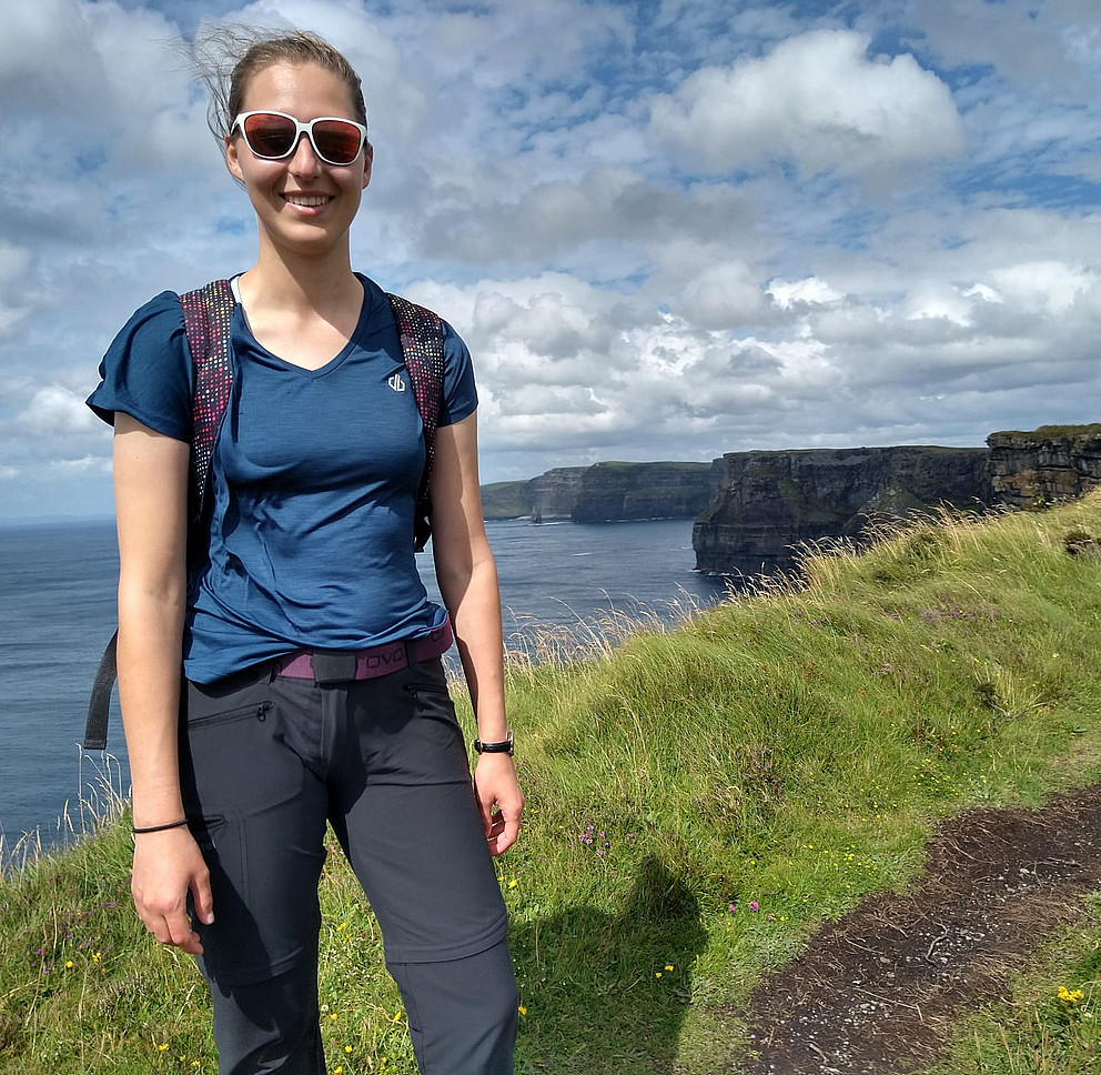 Das Bild zeigt Elisabeth Huber vor den Cliffs of Moher in Irland