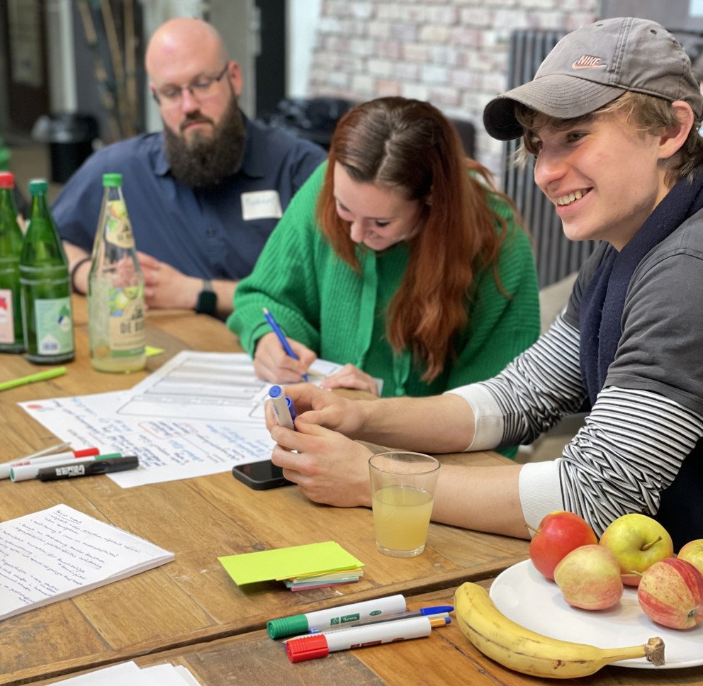 Junge Menschen an einem Tisch, die an Ideen arbeiten