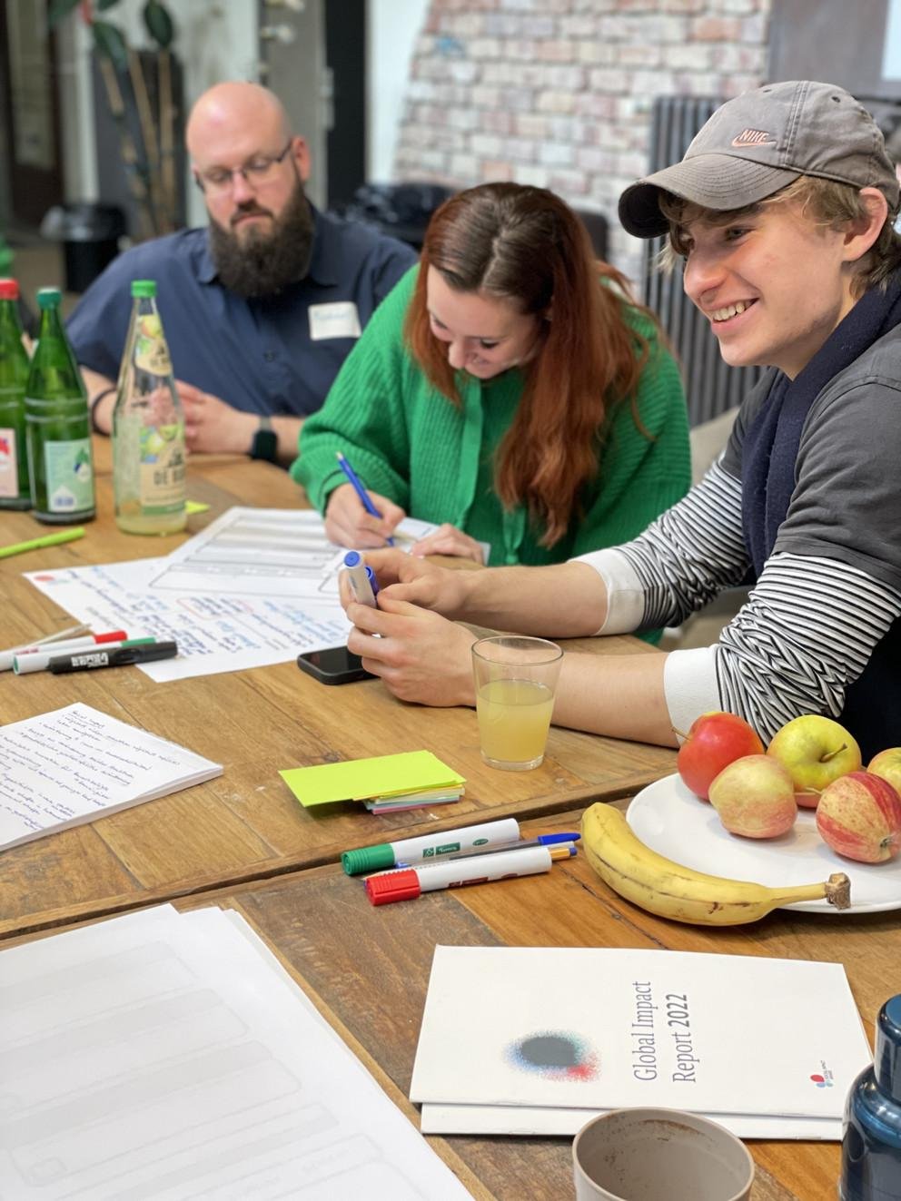 Junge Menschen an einem Tisch, die an Ideen arbeiten