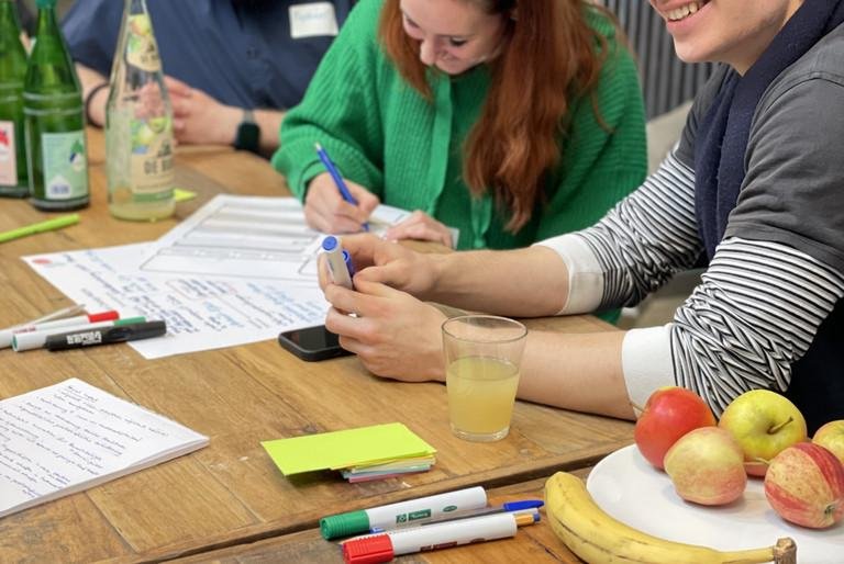 Young people sitting on a table and working on their ideas
