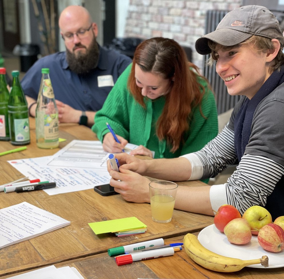 Young people sitting on a table and working on their ideas