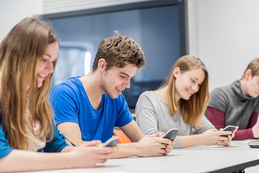 Studierende halten ihre Handys in der Hand