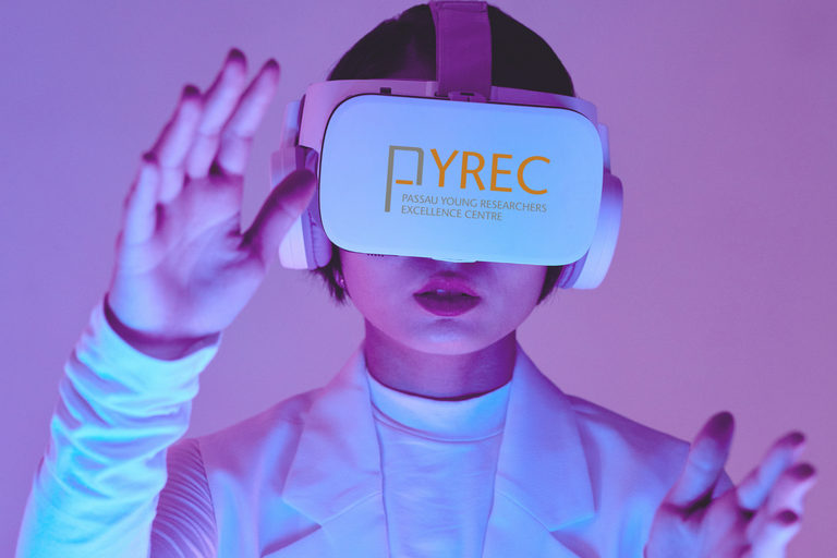 Person in Frontalansicht mit weier VR-Brille die das Pyrec-Logo trgt