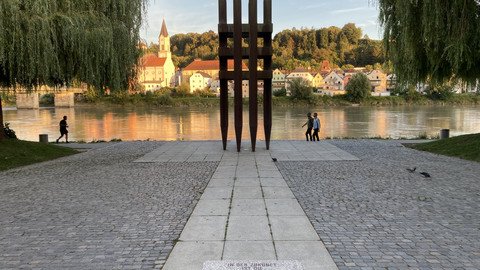 [Translate to Tschechisch:] Blick vom beschrifteten Granitwürfels auf das Denkmal