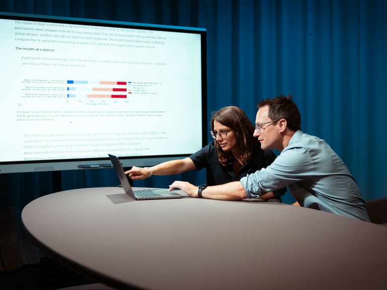 Professors Annette Hautli-Janisz and Steffen Herbold are pointing to a graph showing that the study participants overwhelmingly rated the imitated responses of the AI model as more authentic.