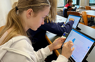 Kinder nutzen Tablets um Roboter zu programmieren.