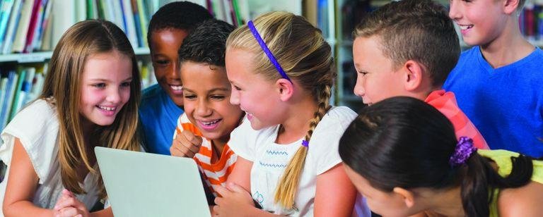 Schulkinder nutzen ein Laptop in der Bibliothek