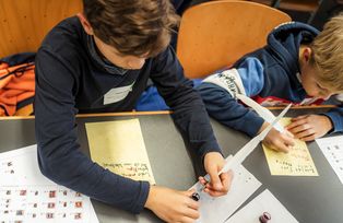 Kinder schreiben mit Feder und Tinte